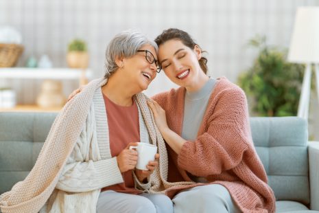 Beautiful mother and daughter are talking and smiling while sitt