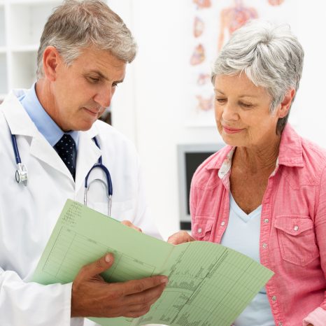 A senior woman and her doctor reviewing what her Medicare plan covers.
