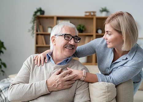 An adult daughter with her senior father discussing Medicare options.