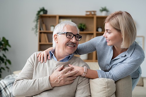 An adult daughter with her senior father discussing Medicare options.