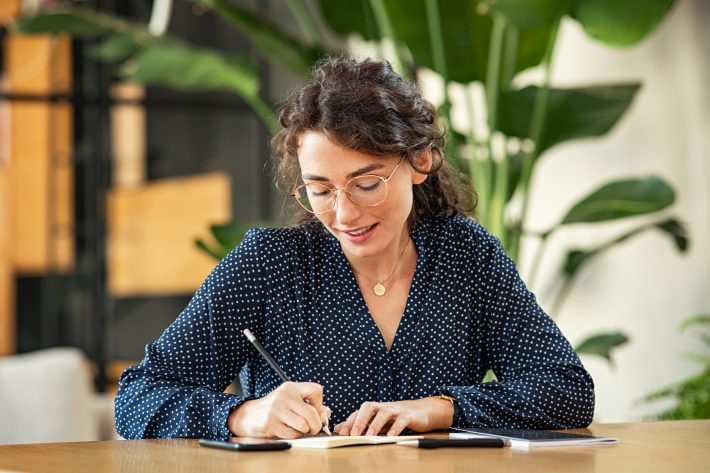 A woman at her desk exploring self-employed health insurance options.