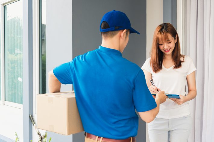 Asian Beautiful Customer Young Woman Signing Delivery In Clipboa