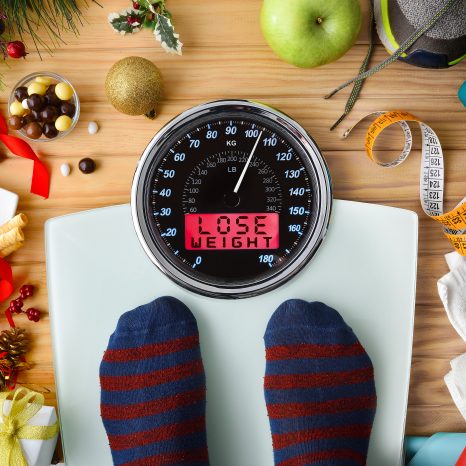 Person Weighing On A Scale After The Christmas Holidays With Mes