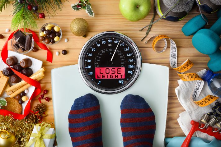Person Weighing On A Scale After The Christmas Holidays With Mes