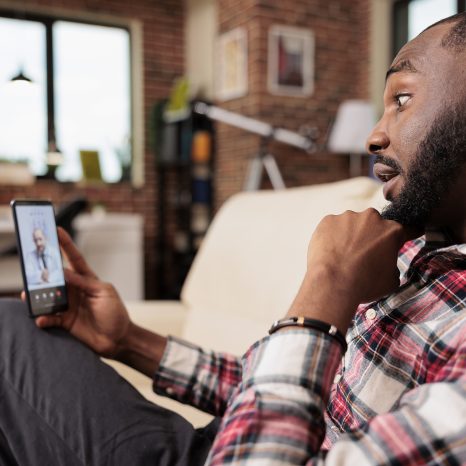 Male Freelancer Talking To Doctor On Videocall With Telehealth O