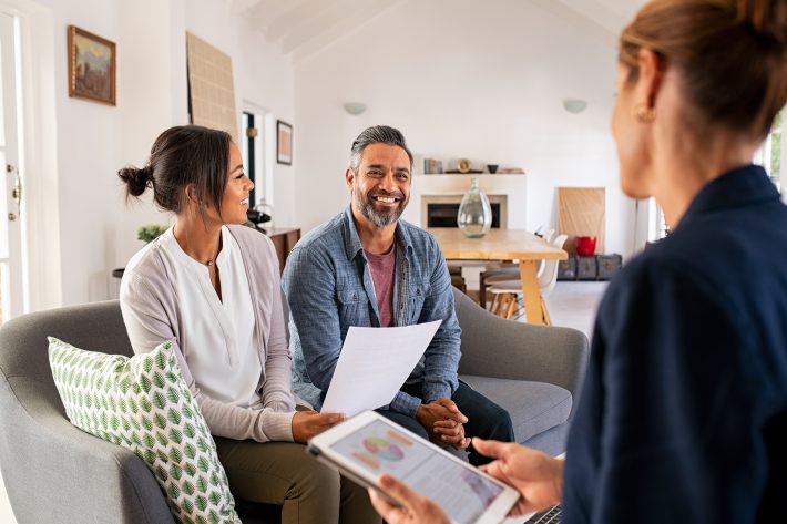 Happy mature couple discussing investments with financial broker