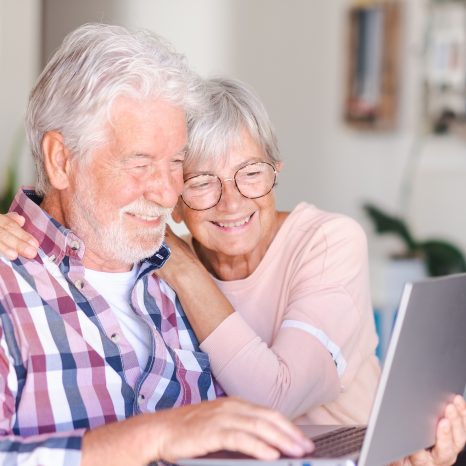 Portrait Of Happy Modern Elderly Couple Browsing Together On Lap