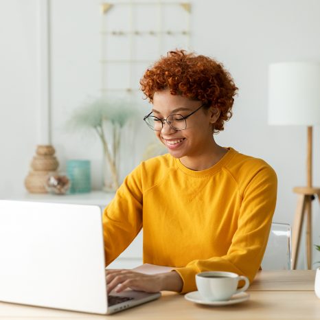 African American Girl Using Laptop At Home Office Looking At Scr