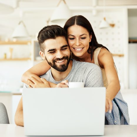 Portrait Of A Young Happy Smiling Couple Using Laptop Together A