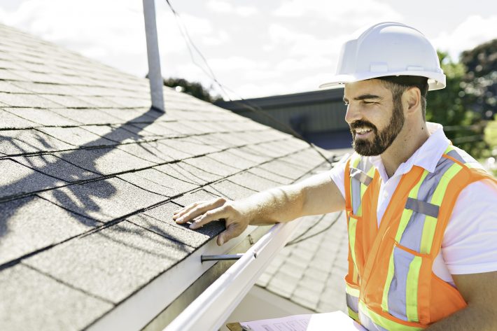 Man In A Hard Hat, Holding A Clipboard, Standing On The Steps Of