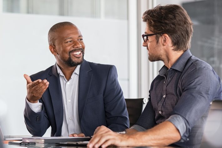 Two happy business colleagues at meeting in modern office interi